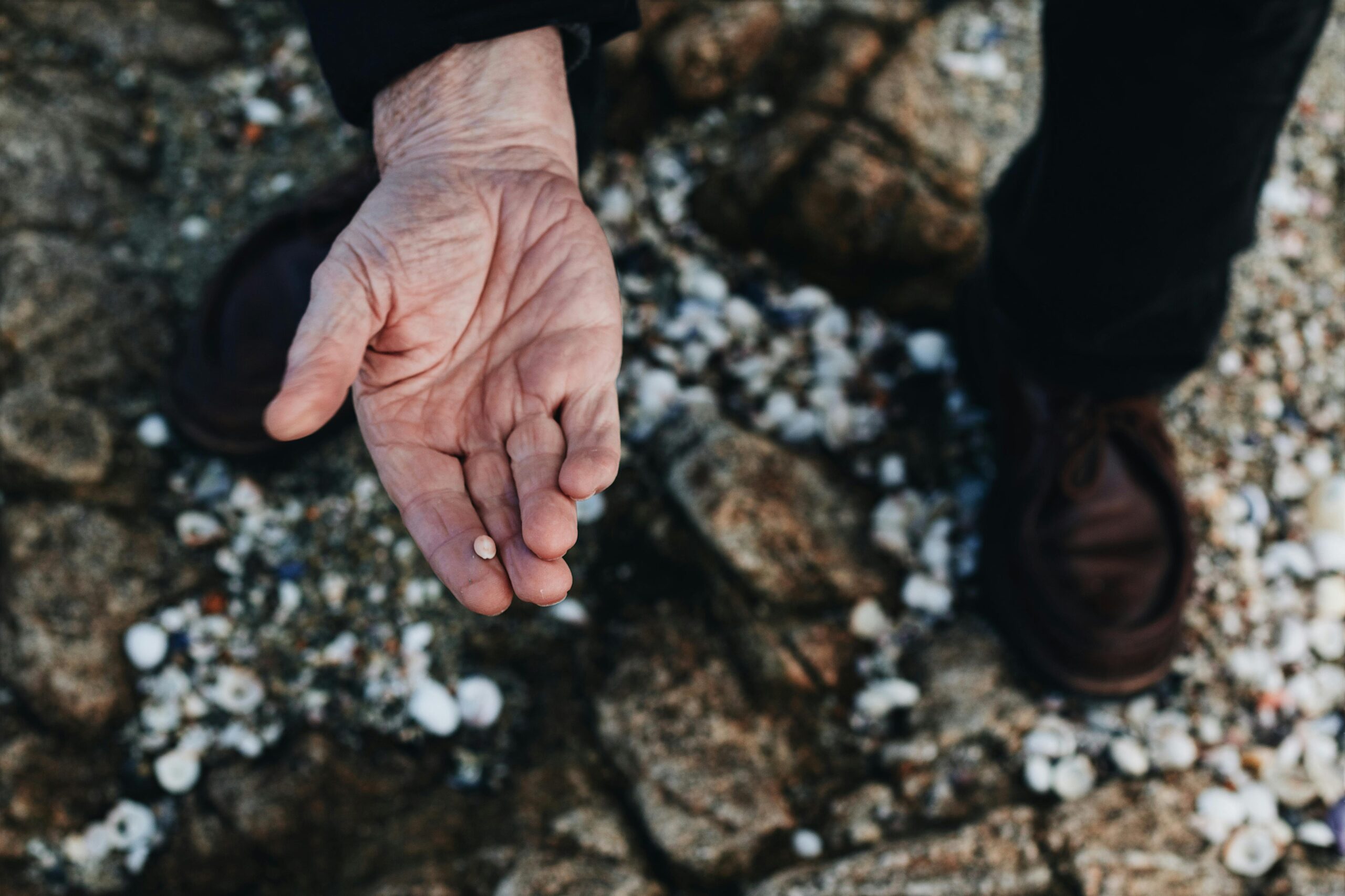 Old hand holding stone to symbolise gallstones.