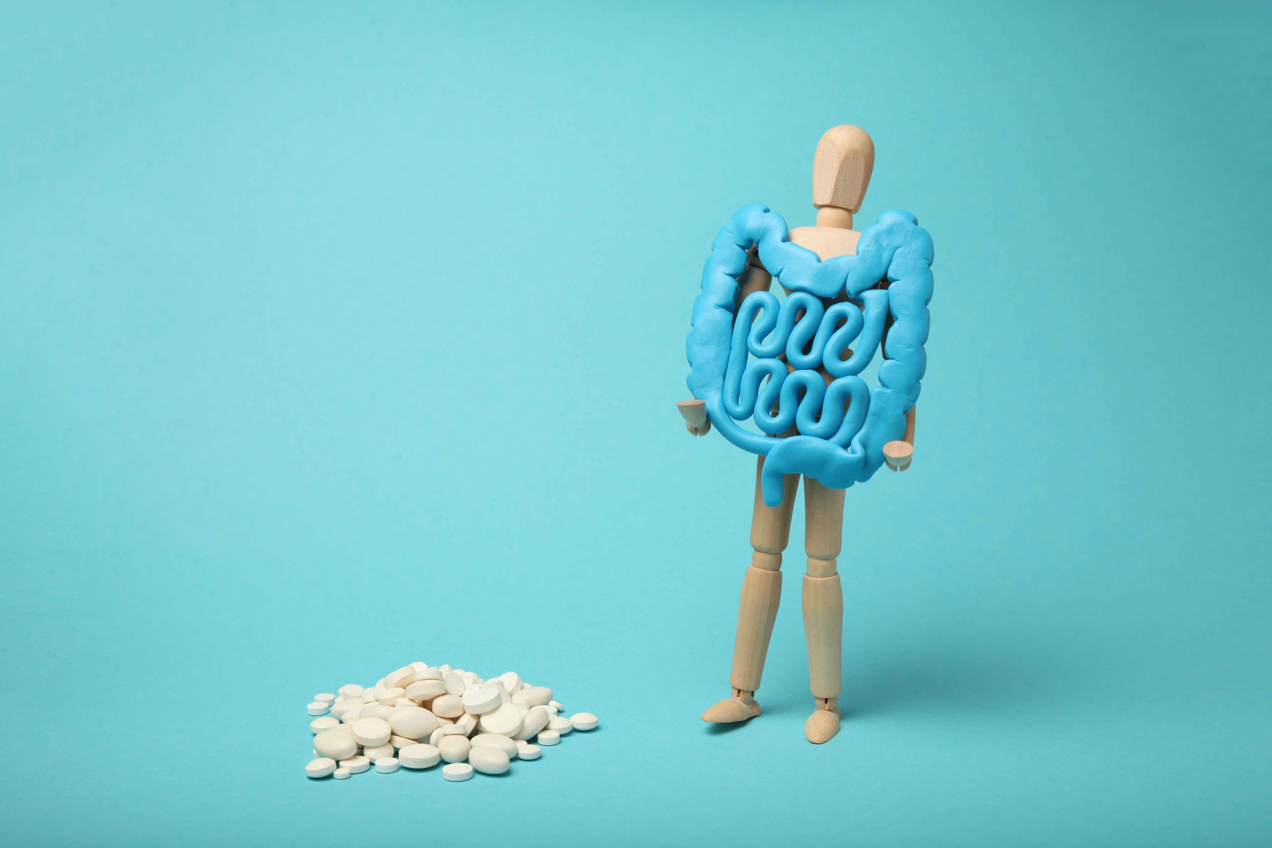 A wooden figure holding a blue bowel.